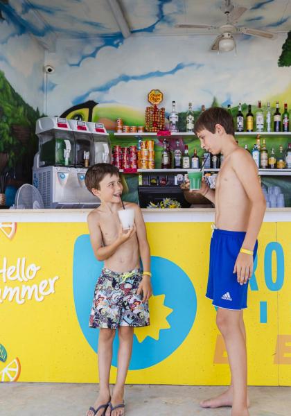 Due ragazzi godono di bevande estive in un chiosco sulla spiaggia.