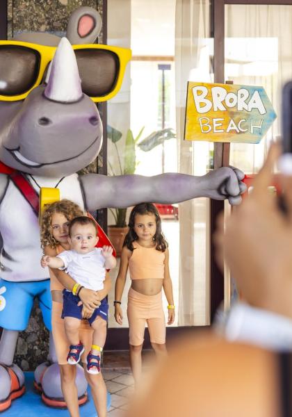 Bambini posano con un rinoceronte gigante davanti a Brora Beach.